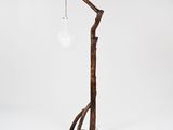 a wooden floor lamp with a light bulb on top of it