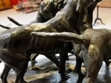 statue représentant un groupe de chiens attaquant un homme dans un musée
