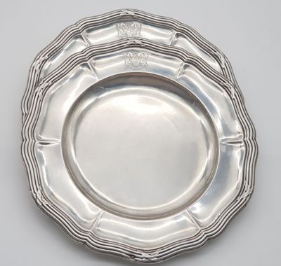 a close up of a silver plate on a white surface