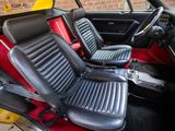 the interior of a car with red and black seats and a black steering wheel