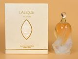 l'image d'un flacon de parfum posé à côté d'une boîte