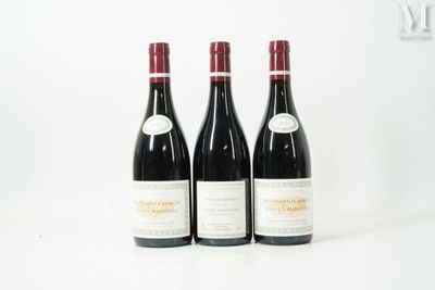 trois bouteilles de vin rouge posées l'une à côté de l'autre sur une surface blanche