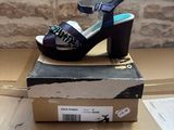 purple high heeled sandals on a cardboard box on top of a cardboard box