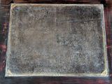 an old metal plate sitting on a wooden table