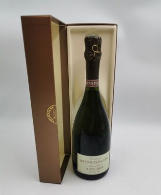 La bouteille de champagne se trouve dans la boîte posée sur la table.