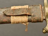 a close up of a sword with a knot on it
