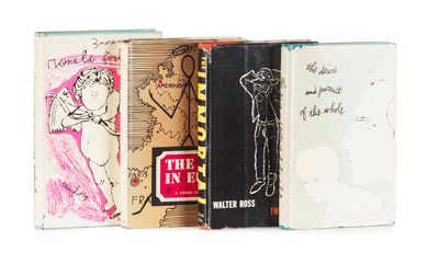 Plusieurs livres sont empilés les uns sur les autres sur une surface blanche.