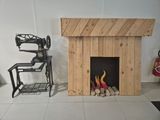 a fire place in the middle of a room with a chair and a chair next to it