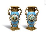 une paire de vases bleus ornés de motifs dorés et d'une peinture