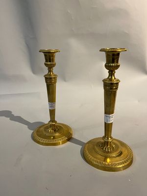 une paire de bougeoirs en laiton sur fond blanc, avec un fond blanc