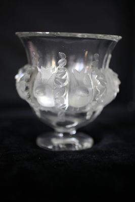 un vase en verre transparent contenant des fleurs, posé sur une surface noire