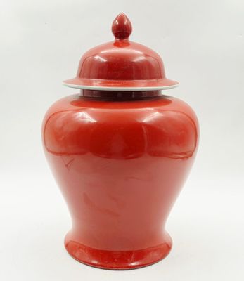 une image représentant un vase rouge muni d'un couvercle, sur fond blanc