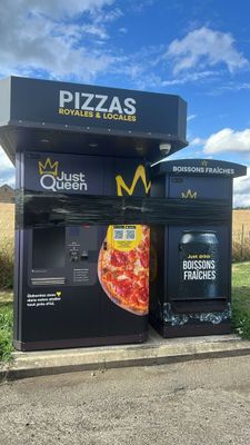 two pizzas that are sitting on the side of the road