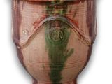 un vase marron avec une anse verte sur fond blanc