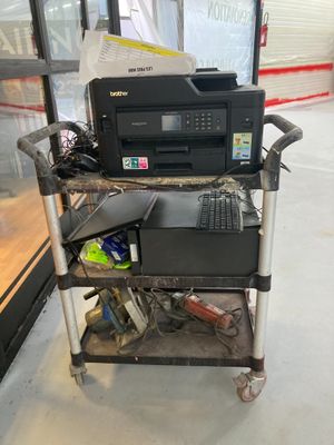 un ordinateur et une imprimante posés sur un chariot dans un magasin