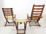 three wooden chairs and a small table in a white room