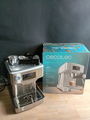une cafetière posée sur une table à côté d'une boîte de café
