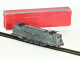 un petit train qui se trouve sur les rails, à côté d'une boîte rouge