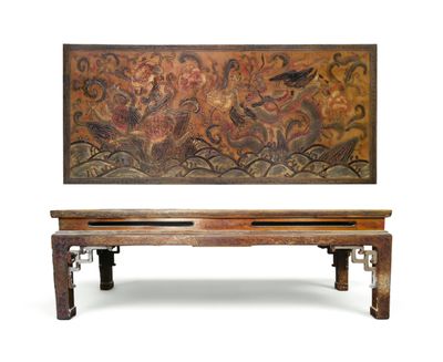 a wooden bench sitting next to a painting on the wall