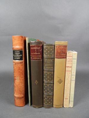 Plusieurs vieux livres sont empilés les uns sur les autres sur une surface grise