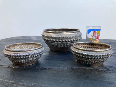 trois bols posés sur une table, contenant des brosses à dents