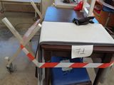 a desk with a chair and a table with a sign on it