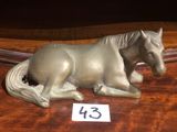 une petite statue représentant un cheval, posée sur une table