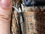 a hand that is holding a zipper in a jacket