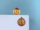 une médaille d'or avec la photo d'une femme dessus