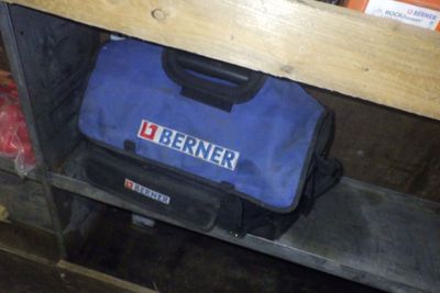 un sac à outils bleu posé sur une étagère dans un garage