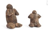 two figurines of a man and a woman sitting on their backs