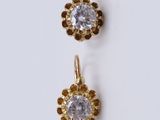 a pair of gold and diamond earrings on a white background