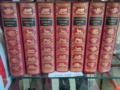 plusieurs livres rouges posés sur une étagère en verre dans une librairie