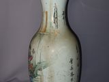 a white vase with a painting on it sitting on a table