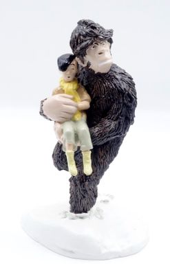 une figurine représentant un homme tenant un enfant dans ses bras