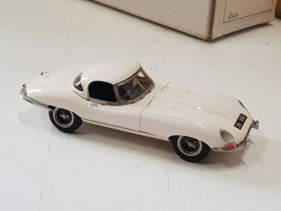 a toy car sitting on the floor next to a refrigerator