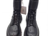 des bottes en cuir noir à lacets et à semelles en caoutchouc sur fond blanc