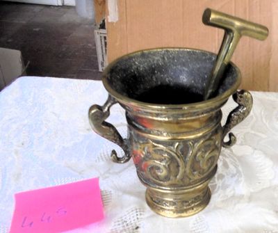 a metal cup with a hammer in it sitting on a table