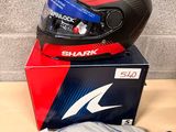a shark helmet on top of a box next to a bag