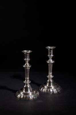 pair of silver candlesticks on a black background