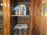 une armoire en bois avec une porte vitrée, dans un coin de la pièce