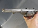 a person holding a gun in their hand in front of a sink