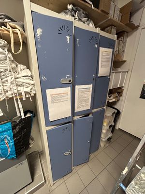 des casiers bleus dans une pièce où sont posés de nombreux objets dessus