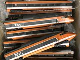 Plusieurs trains orange et noirs se trouvent dans une boîte posée sur une table