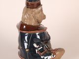 a ceramic figurine of a dog sitting on a shoe
