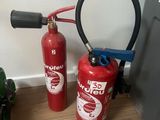 two fire extinguisors sitting next to each other on the floor