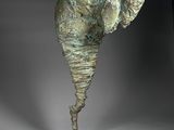 bronze sculpture of an elephant standing on a rock with its trunk in the air