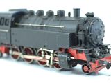 a black and red model train on a white surface