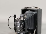 une vieille photo représentant un vieil appareil photo posé sur une surface blanche