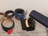 many belts and other accessories sitting on a clear tray